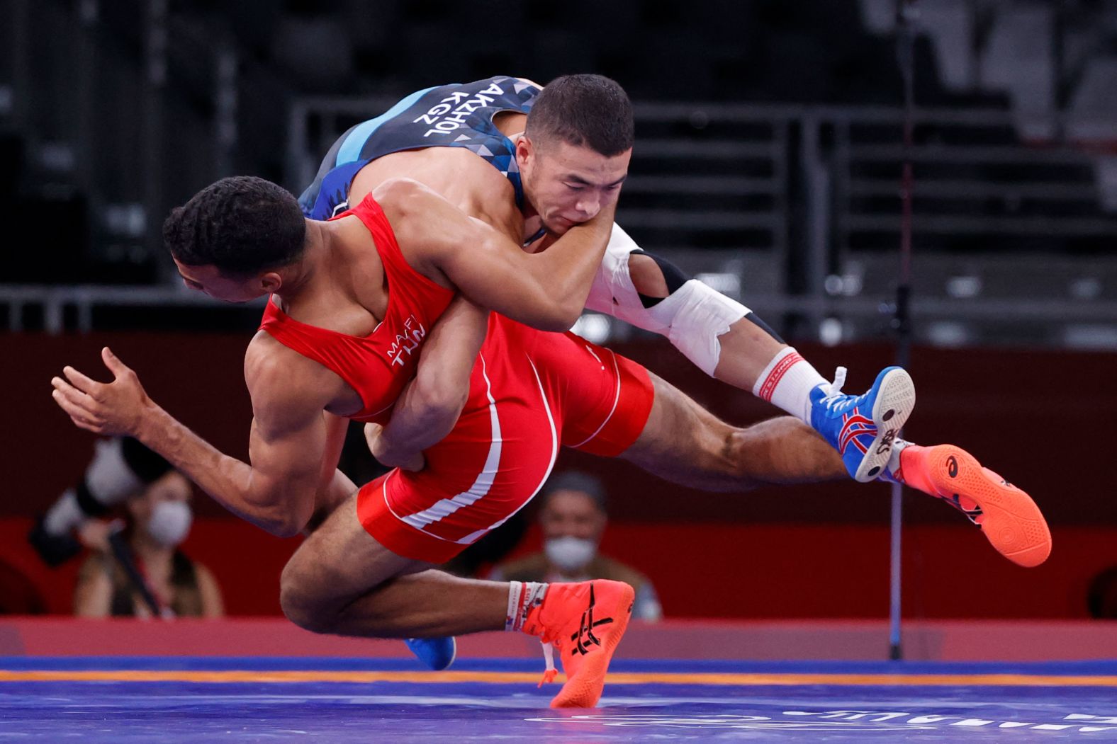 Kyrgyzstan's Akzhol Makhmudov, top, competes against Tunisia's Lamjed Maafi in Greco-Roman wrestling on August 2. Makhmudov went on to win a silver medal.