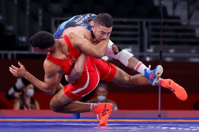 Kyrgyzstan's Akzhol Makhmudov, top, competes against Tunisia's Lamjed Maafi in Greco-Roman wrestling on August 2. Makhmudov went on to win a silver medal.