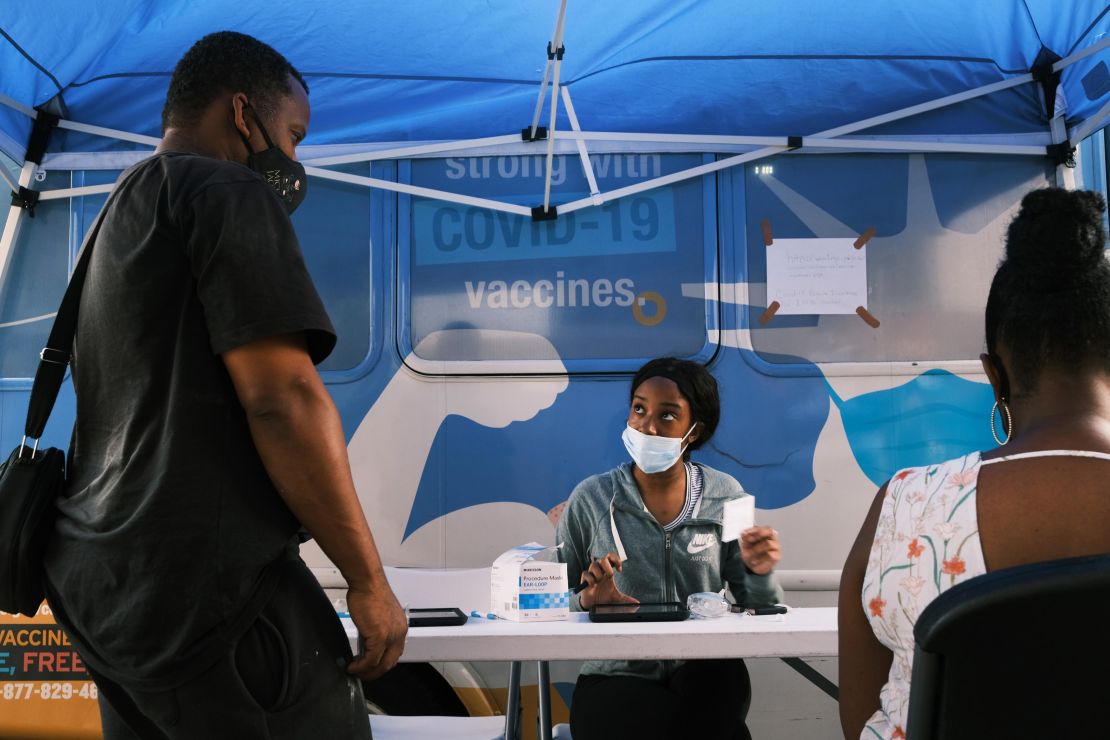People sign up for vaccinations at a mobile clinic in Brooklyn. New York City will soon require proof of vaccination for indoor dining and gyms, in an effort to curtail a third wave of infections.