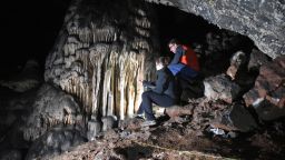 Researchers looking toward the massive speleothem of Cueva Ardales, with archaeological trench in the foreground.