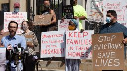 People from a coalition of housing justice groups hold signs protesting evictions during a news conference outside the Statehouse, Friday, July 30, 2021, in Boston. 