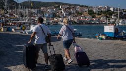 Visitors transport their luggage on the eastern Aegean island of Samos, Greece, Tuesday, June 8, 2021. (AP Photo/Petros Giannakouris)