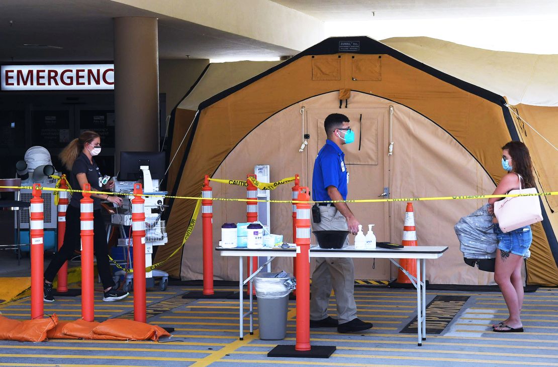 A woman arrives at a treatment tent outside the emergency department at Palm Bay Hospital in Brevard County, Florida, on July 29, 2021.