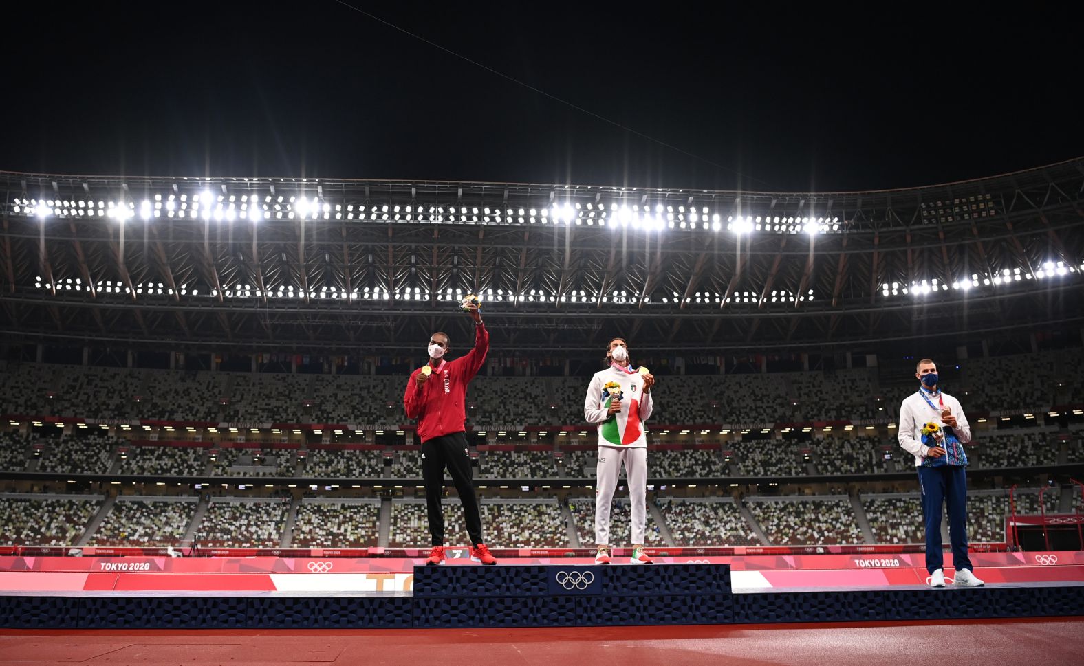 Qatar's Mutaz Essa Barshim, left, and Italy's Gianmarco Tamberi share the podium during a medal ceremony on August 2. <a href="index.php?page=&url=https%3A%2F%2Fwww.cnn.com%2Fworld%2Flive-news%2Ftokyo-2020-olympics-08-01-21-spt%2Fh_86532abc405785d7c29b0fda0e27cdce" target="_blank">They agreed to share the gold medal in high jump</a> after they both cleared 2.37 meters but failed to clear 2.39. Beside them is bronze medalist Maksim Nedasekau of Belarus. No one was given a silver medal.