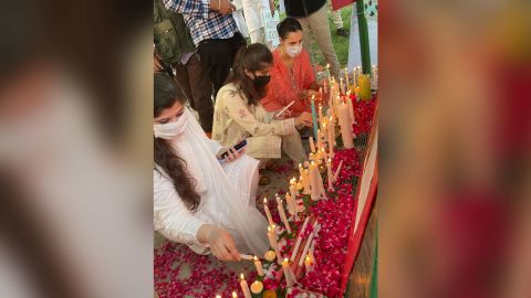 Women light candles at a vigil for Noor Mukadam in Islamabad.