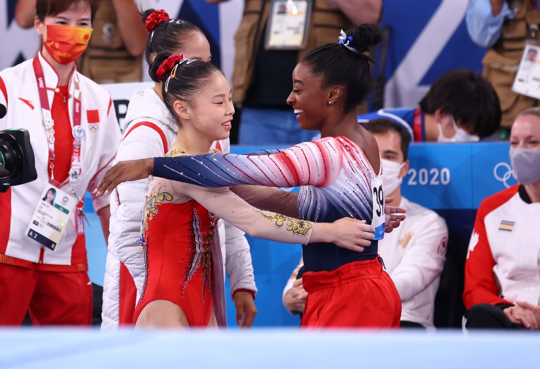 Biles and Guan embrace during the balance beam final. 