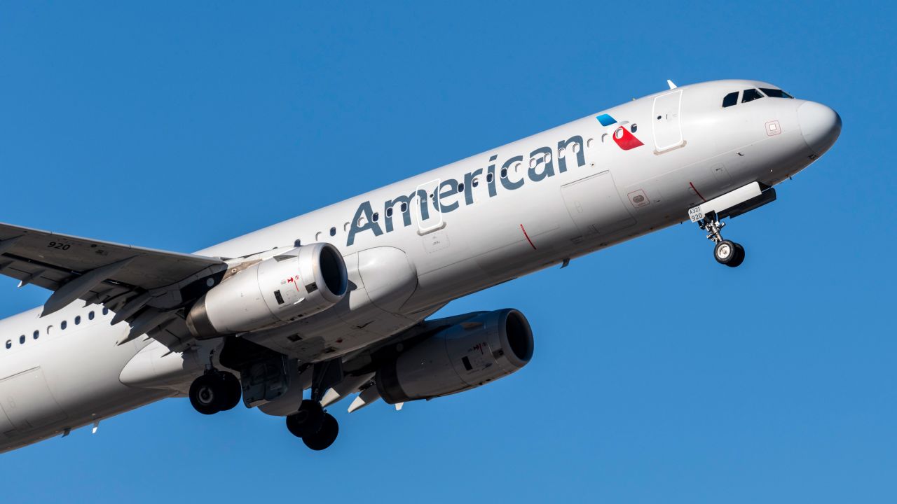 An American Airlines plane taking off into a blue sky.