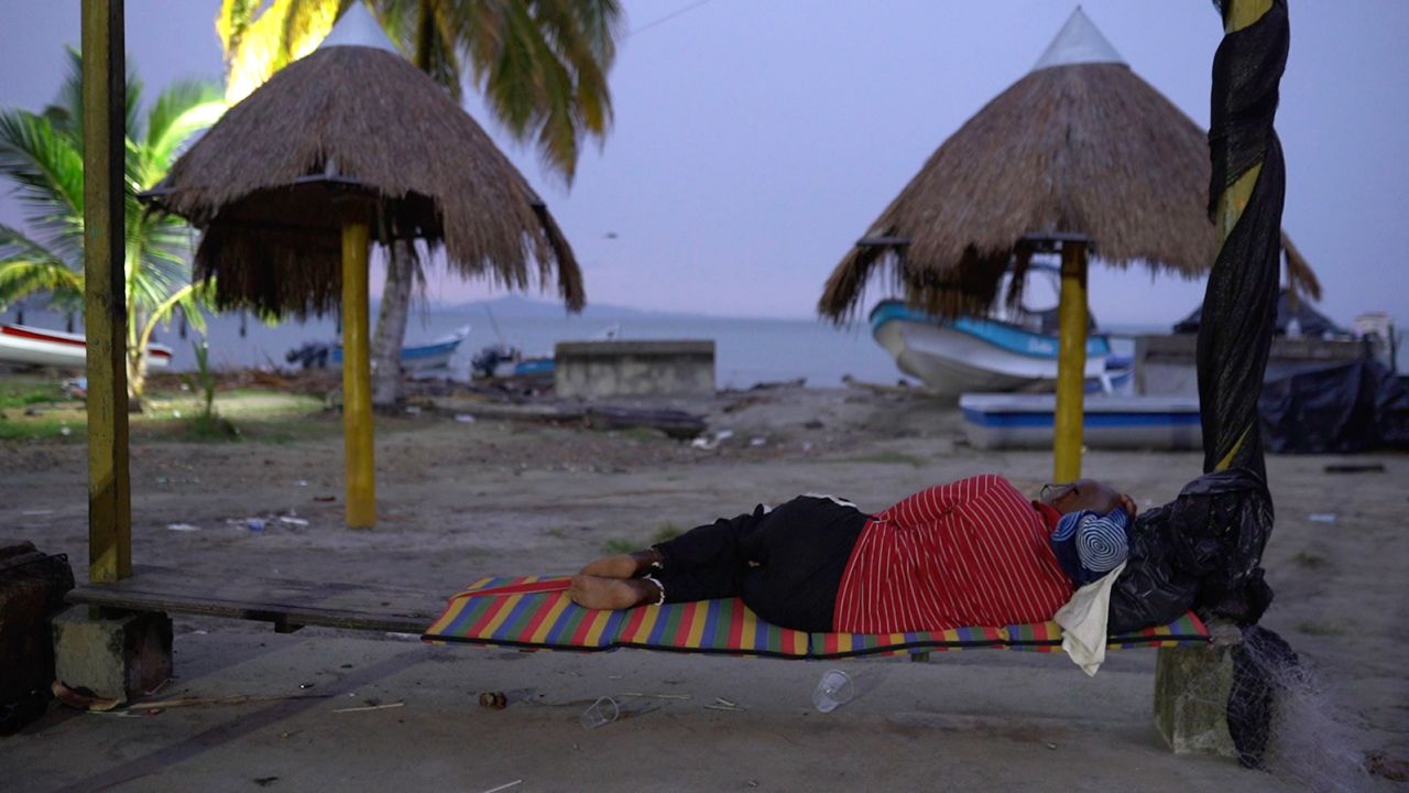 A migrant sleeps on the beach in Necocli on July 31, 2021.