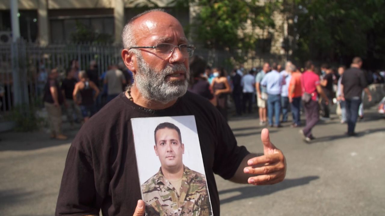Elias Maalouf stands outside the justice ministry in Beirut holding up a photograph of his son George, who was killed in the blast.