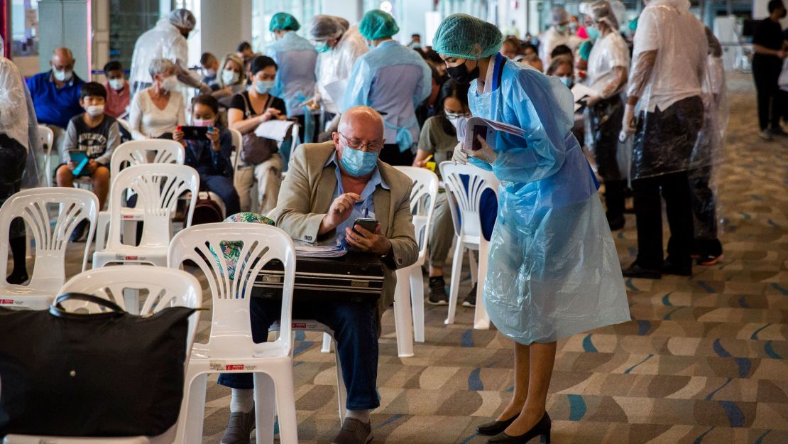 Phuket International Airport staff and medical personnel wear personal protective equipment as they help travelers entering Phuket on July 18, 2021.