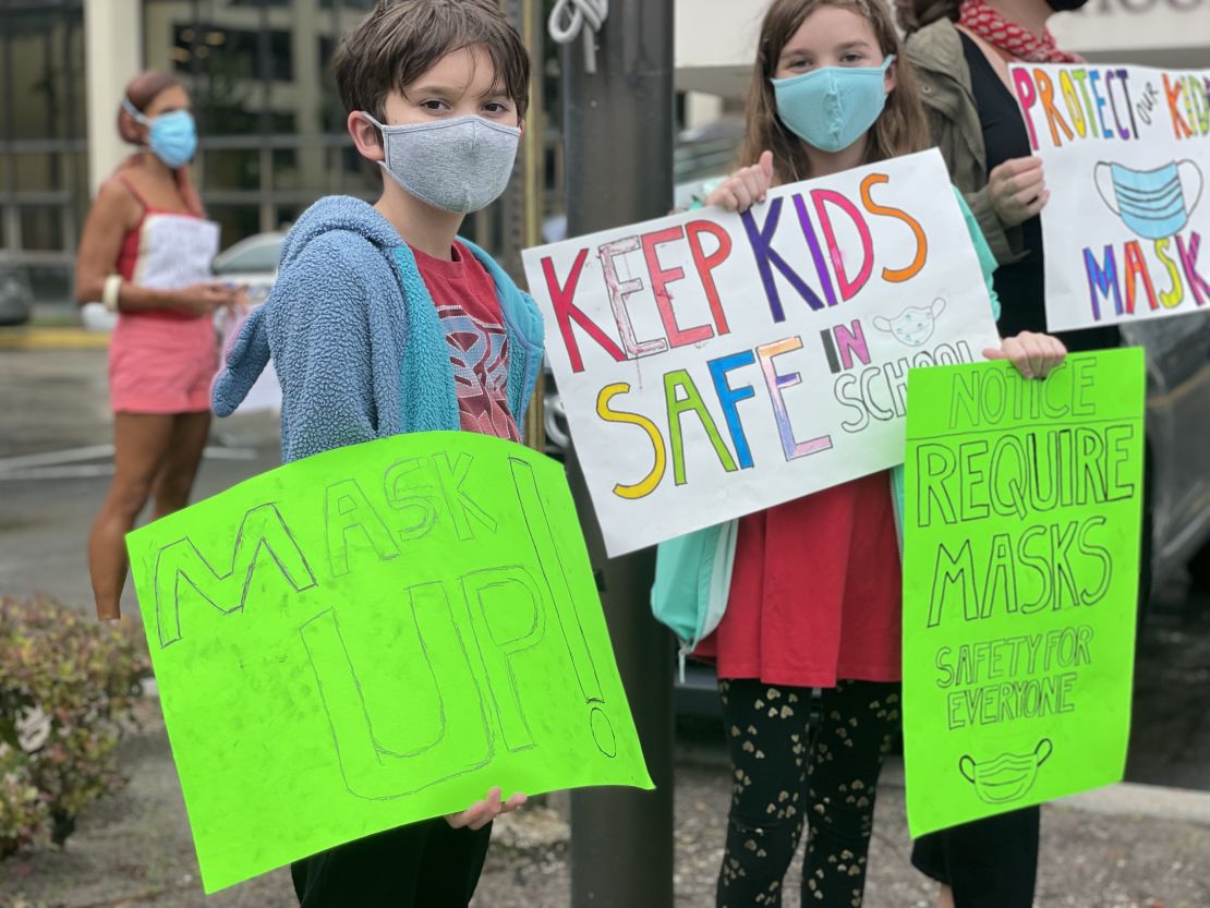 Will and Lila Hartley demonstrate for masks outside Tuesday's school board meeting.