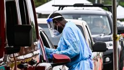 Medical personnel conduct Covid-19 testing at a "drive-through" site in Miami, on August 3, 2021. - In Florida cars are lining up for Covid-19 testings once again, amid record hospitalizations, as Florida Governor Ron DeSantis downplays the outbreaks severity, blaming media hysteria. (Photo by CHANDAN KHANNA / AFP) (Photo by CHANDAN KHANNA/AFP via Getty Images)