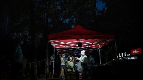 A medical worker takes samples during a mass Covid-19 test inside a residential compound in Wuhan on August 3, 2021.