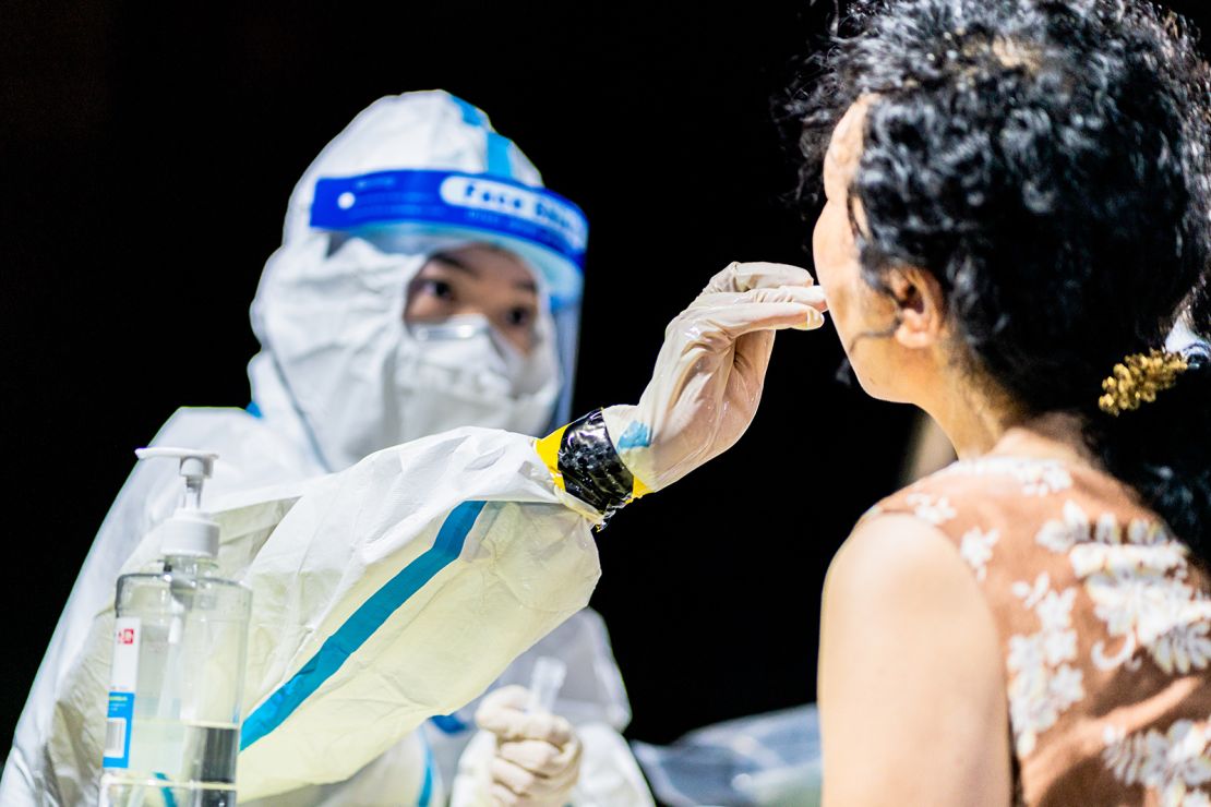 A medical worker collects a throat swab sample from a citizen for nucleic acid testing during a citywide Covid-19 testing campaign on August 3, 2021, in Wuhan, Hubei province of China.