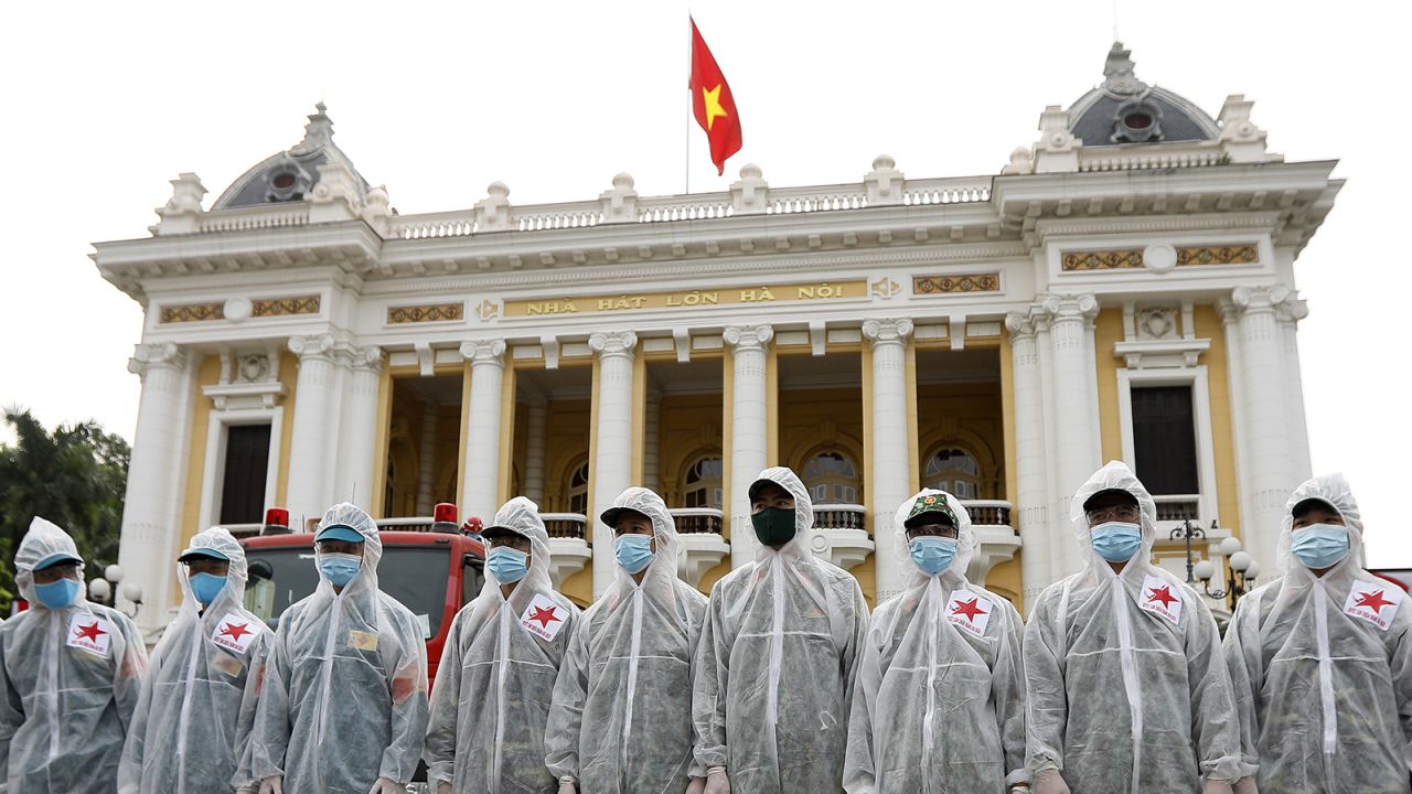 Soldiers from the High Command of Chemicals under Vietnam's Ministry of National Defence before spraying disinfectant throughout the streets of Hanoi on July 26.