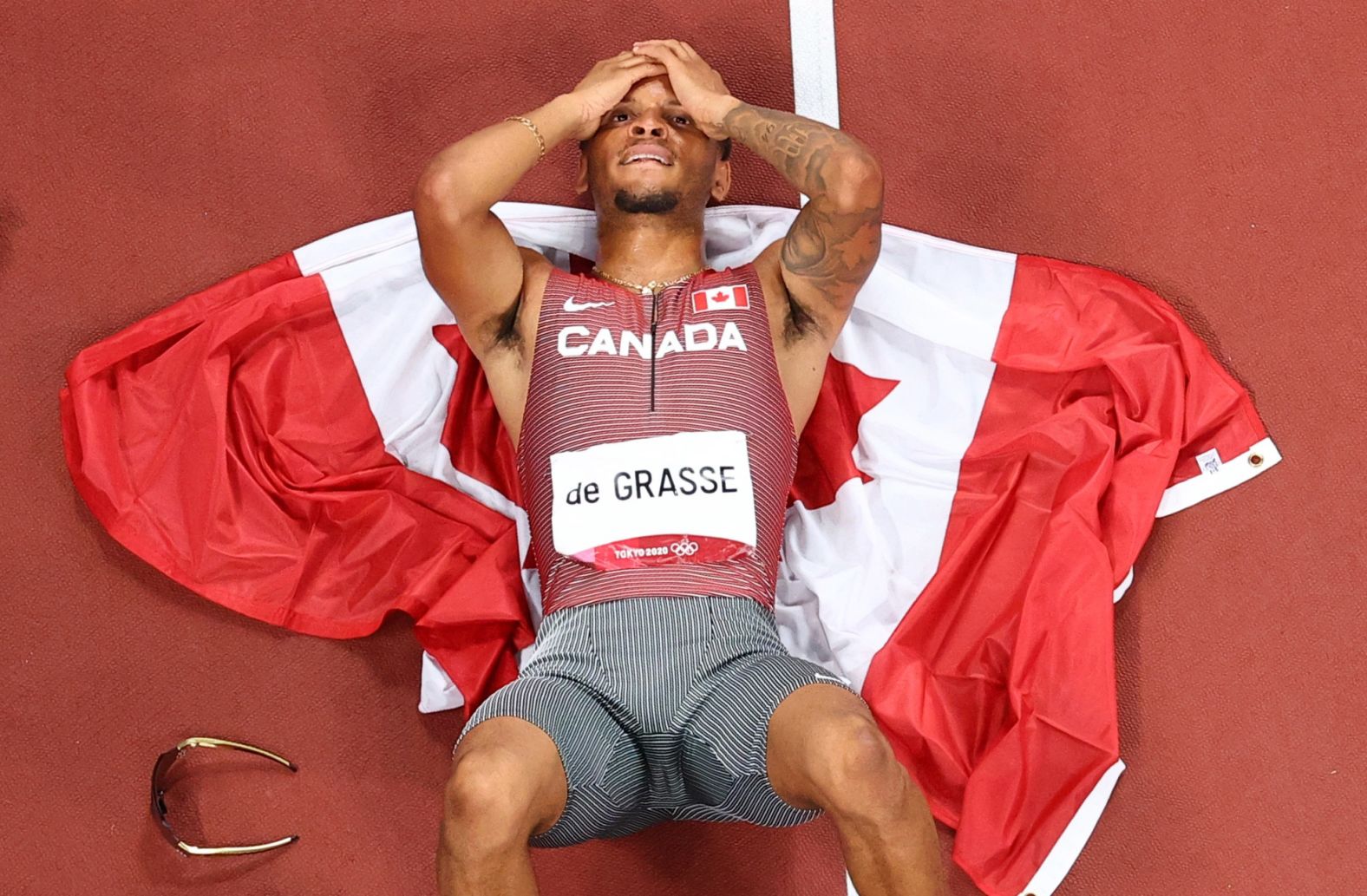 Canadian sprinter Andre De Grasse lies on the track after <a href="index.php?page=&url=https%3A%2F%2Fwww.cnn.com%2Fworld%2Flive-news%2Ftokyo-2020-olympics-08-04-21-spt%2Fh_329822ffaa1cc67218da92bea7a9c900" target="_blank">winning the 200-meter final</a> on August 4. It's the first Olympic gold for De Grasse, who won bronze in the 100 this year and was the silver medalist in the 200 five years ago.
