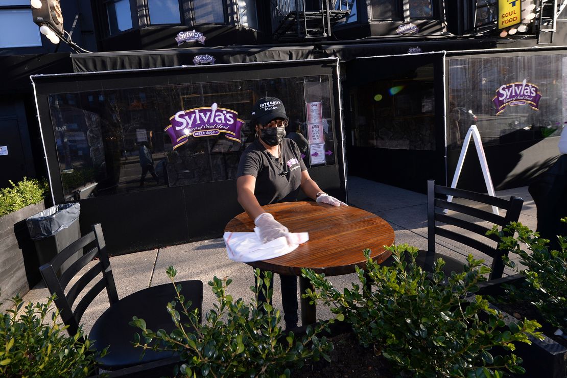 A Sylvia's staff member wipes down an outside table in December 2020.