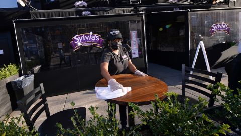 A Sylvia's staff member wipes down an outside table in December 2020.