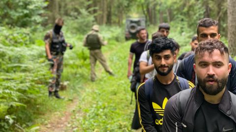 Iraqi migrants walk through the Lithuanian forest.