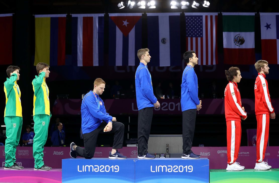 Race Imboden (third from left) takes the knee during the National Anthem Ceremony in the podium of men's foil team gold medal match at the 2019 Pan American Games in Lima, Peru. 