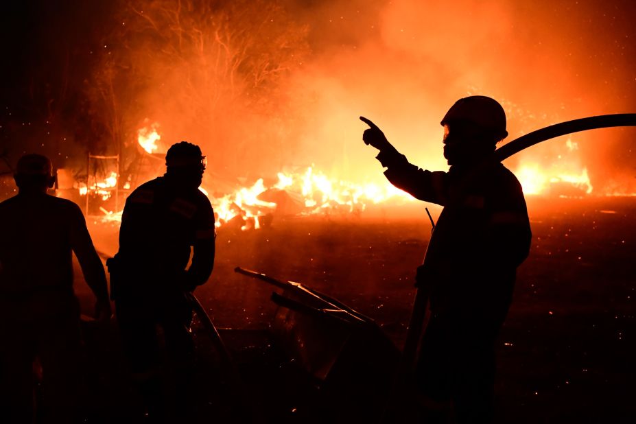 Firefighters work as a house burns in the Adames area of northern Athens on August 3.