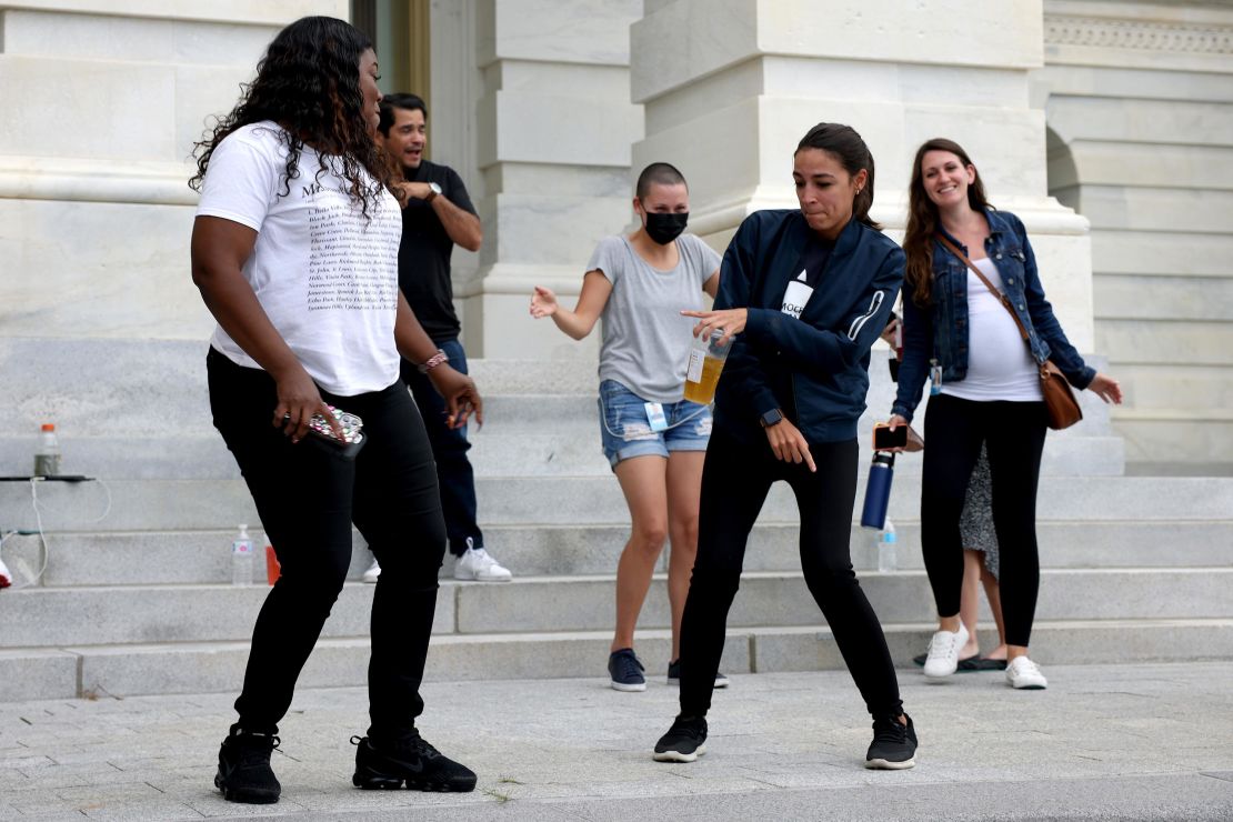 Rep. Cori Bush is joined by Rep. Alexandria Ocasio-Cortez at right, as they dance in celebration near the entrance to the Capitol Building on Tuesday.