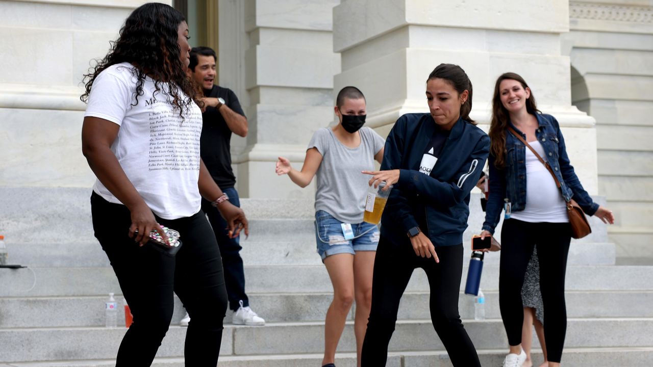 Rep. Cori Bush is joined by Rep. Alexandria Ocasio-Cortez at right, as they dance in celebration near the entrance to the Capitol Building on Tuesday.