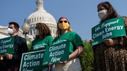Activists look on as Senate Majority Leader Chuck Schumer speaks during a news conference about climate change outside the U.S. Capitol on July 28, 2021 in Washington, DC.