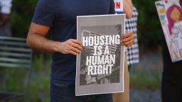 A man holds a placard that says Housing is a human right during rally for housing rights in front of the Greater Columbus Convention Center with other housing advocates on June 30, 2021. 