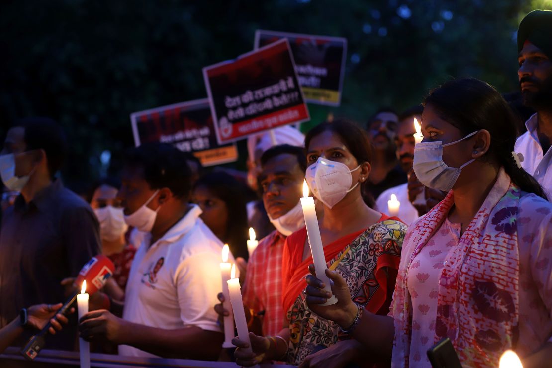 Protesters march with lit candles and placards on August 4 in Delhi, India. 