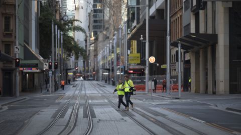 Tradesmen cross a near-empty street in Sydney, Australia, on August 2.