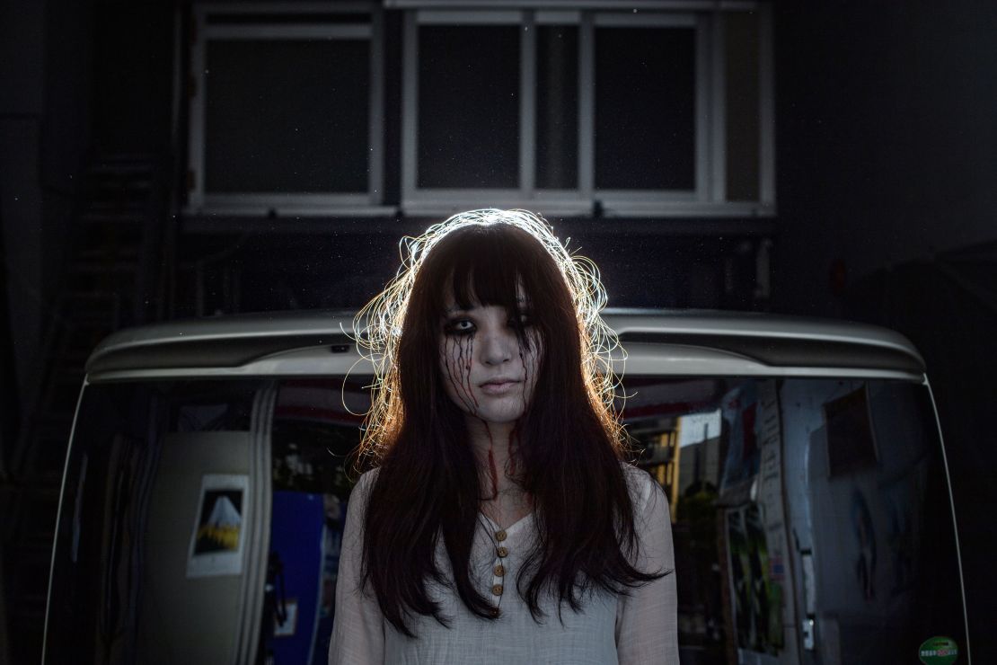 This picture taken on June 15, 2020 shows a drive-in haunted house actress posing for a photo in a Tokyo garage.