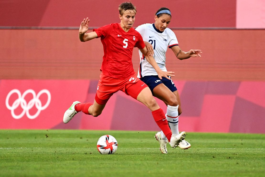 Canada's midfielder Quinn is marked by USA forward Lynn Williams (R) during the Olympic semi match.