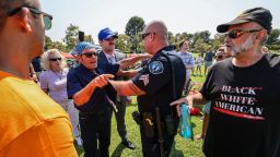 Police restrain vocal opponents of Representative Katie Porter following a brief scuffle during a town hall meeting at Mike Ward Community Park in Irvine, California on July 11. 