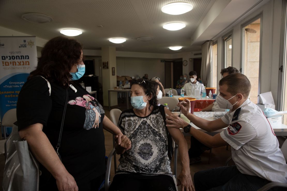 An Israeli woman receives a third coronavirus vaccine at a senior center in Jerusalem on Wednesday.