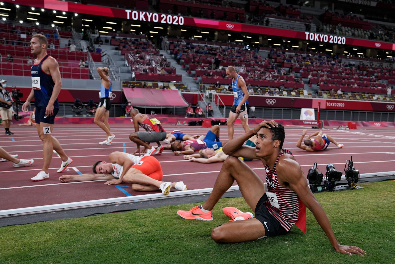 Decathletes rest on the track following the 1,500 meters on August 5.