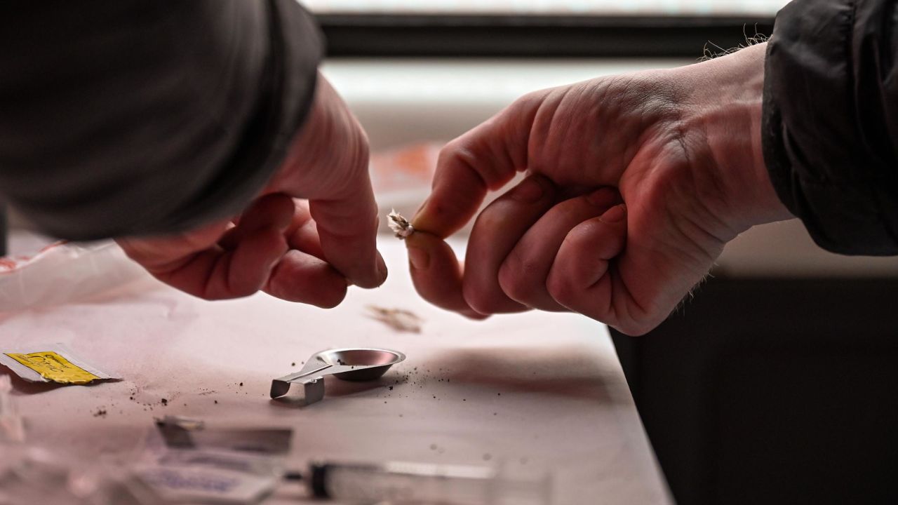 A drug user prepares heroin before injecting, inside a Safe Consumption van in September 2020, in Glasgow, Scotland.