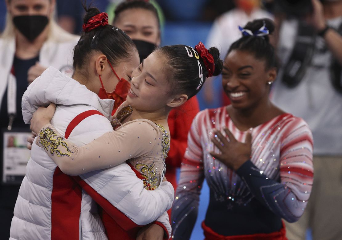 Chinese gymnasts  Tang Xijing and Guan Chenchen, and US gymnast Simone Biles celebrate after the women's balance beam final at the Tokyo Olympics on August 3. 