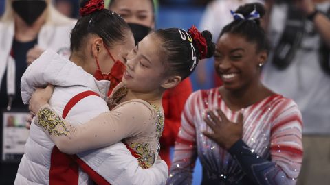 Chinese gymnasts  Tang Xijing and Guan Chenchen, and US gymnast Simone Biles celebrate after the women's balance beam final at the Tokyo Olympics on August 3. 