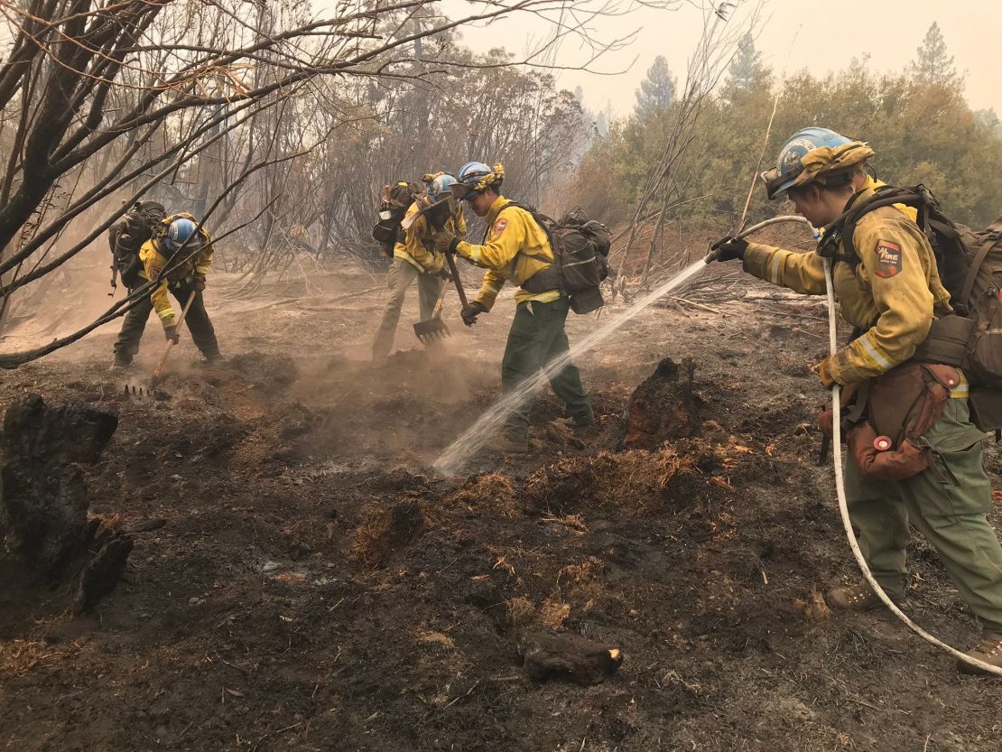 California Conservation Corps members from the Magalia Fire Camp on Thursday, Aug. 5, 2021, extinguish hot spots from the Dixie Fire that burned around Chester on Wednesday.