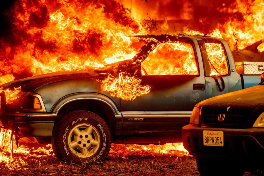 Flames from the Dixie Fire consume a pickup truck on Highway 89, south of Greenville, California, on August 5.