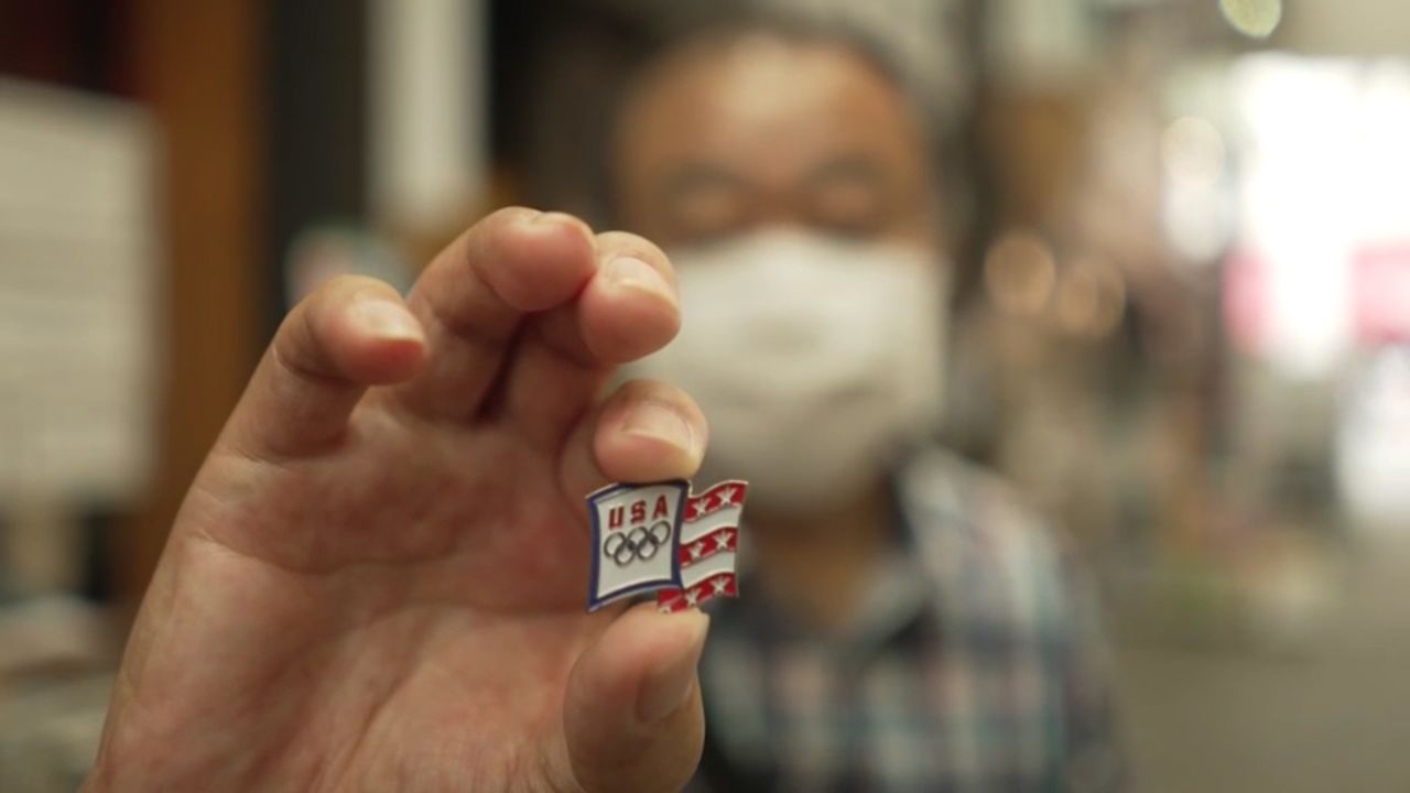 A man in Tokyo holds up US-themed pin.