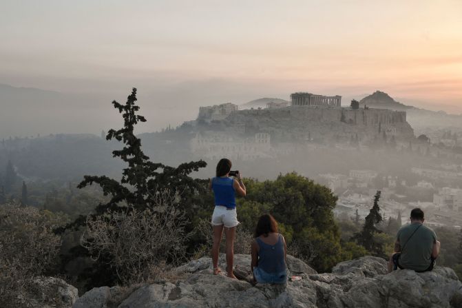 Onlookers view the smoke from the wildfires blanketing Athens' Acropolis on August 4.