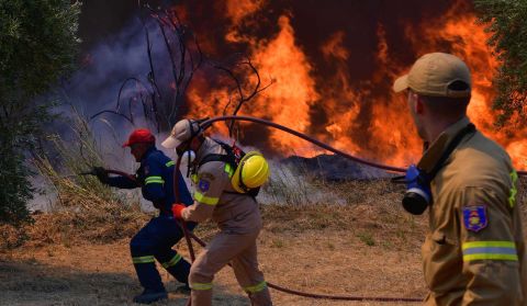 Firefighters try to extinguish a wildfire near the town of Olympia, Greece, on August 5.