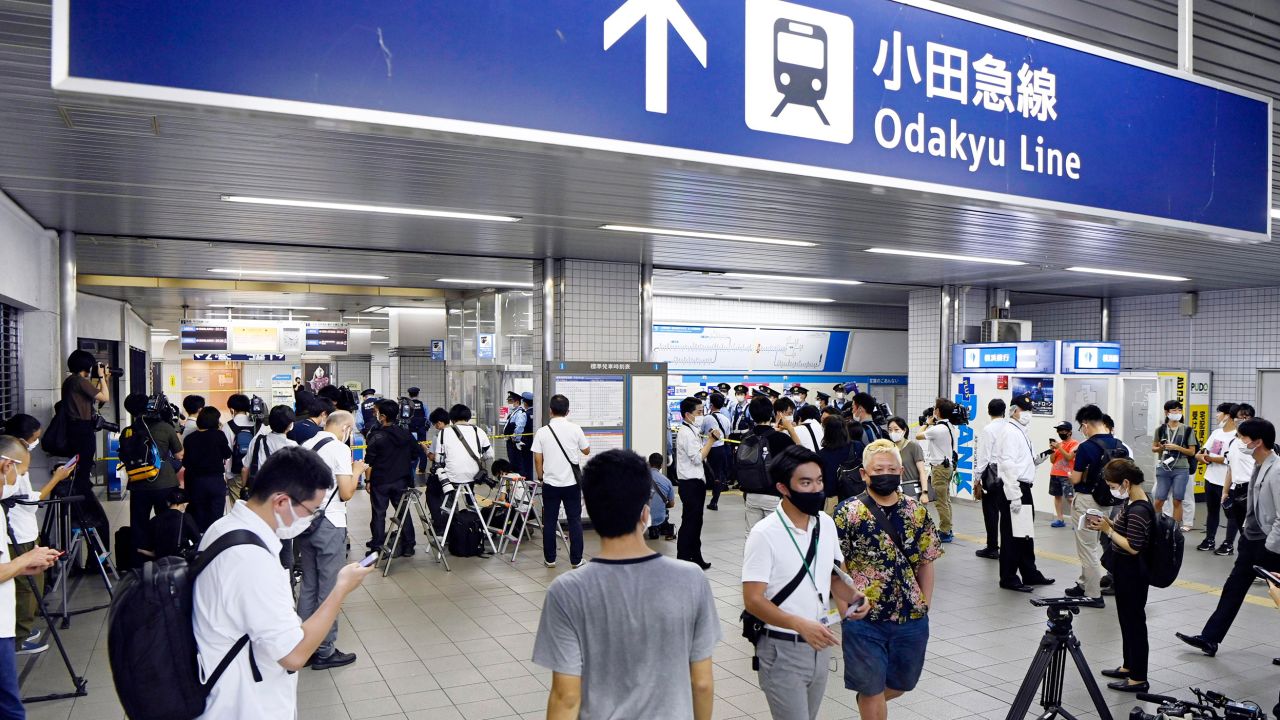 Police and media gather at Soshigaya-Okura Station in Tokyo on Friday following the incident.