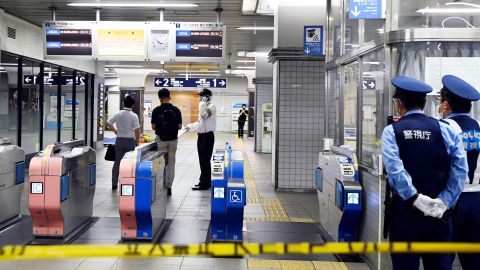 周五，东京通勤列车被刺伤后，警察站在 Soshigaya-Okura 站关闭的检票口。