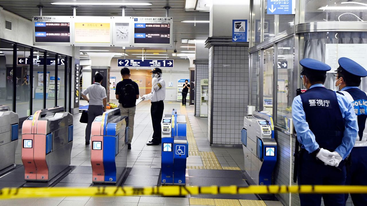 Policemen stand as ticket gates are sealed off at Soshigaya-Okura Station after a stabbing on a commuter train in Tokyo on Friday.