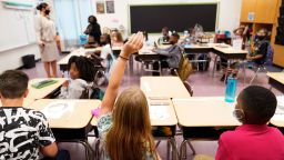 A student raises their hand in a classroom at Tussahaw Elementary School on Wednesday, August 4, 2021, in McDonough, Georgia. Schools have begun reopening in the U.S. with most states leaving it up to local schools to decide whether to require masks.