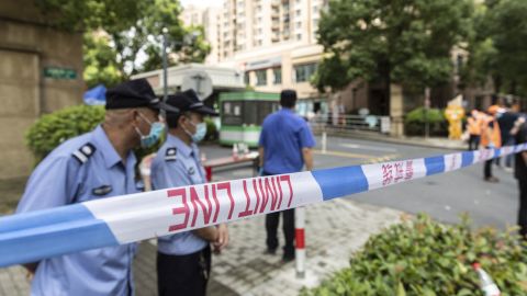 Police, security guards and volunteers help enforce a cordon around a neighborhood placed under lockdown after a resident tested positive for Covid-19, in Shanghai, China, on August 3, 2021. 