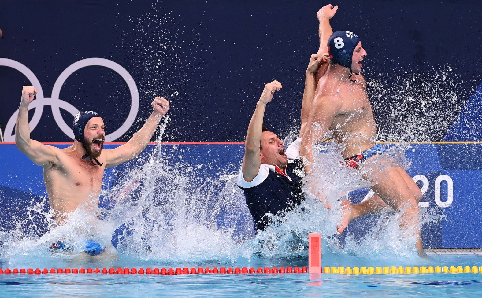 Serbia's Nikola Dedović, Vladimir Vujasinović and Milan Aleksić jump into the pool as they celebrate winning <a href="index.php?page=&url=https%3A%2F%2Fwww.cnn.com%2Fworld%2Flive-news%2Ftokyo-2020-olympics-08-08-21-spt%2Fh_a15625c29c75324d0b2fcf55f37f79ac" target="_blank">the water polo final against Greece </a>on August 8. Serbia won the match 13-10.
